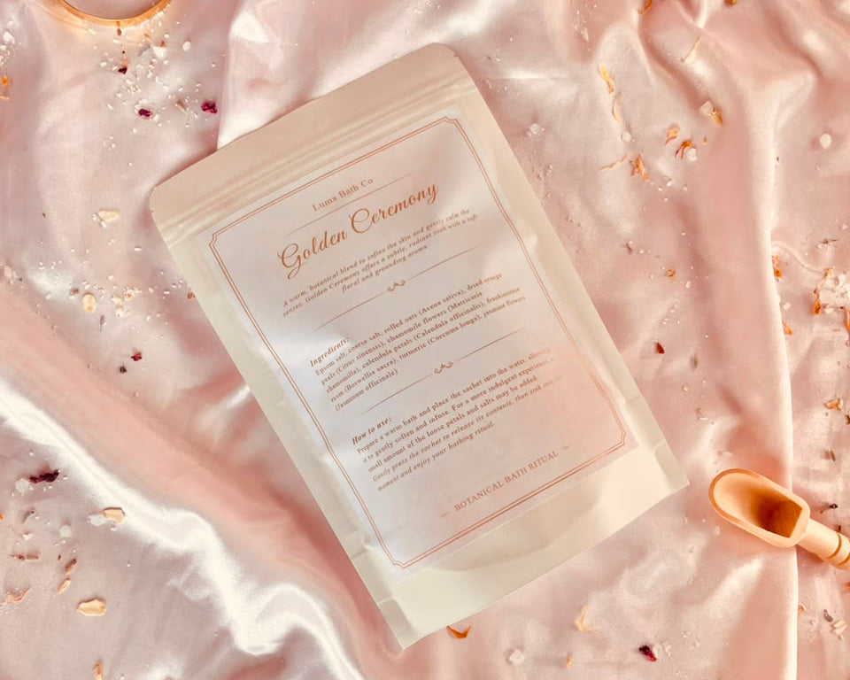 Back of LUMA Golden Ceremony bath tea pouch showing ingredients — chamomile, calendula, frankincense and orange peel